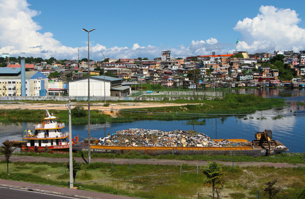 Balsa transporta lixo em rio na cidade de Manaus