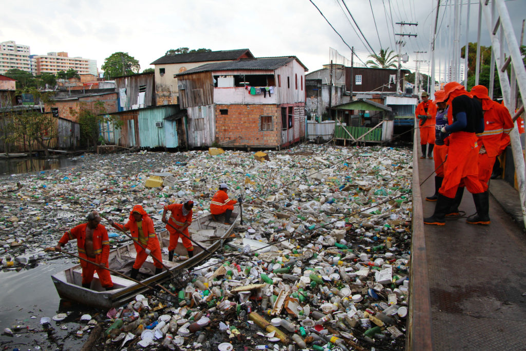 Garis trabalham em limpeza de igarapé repleto de lixo