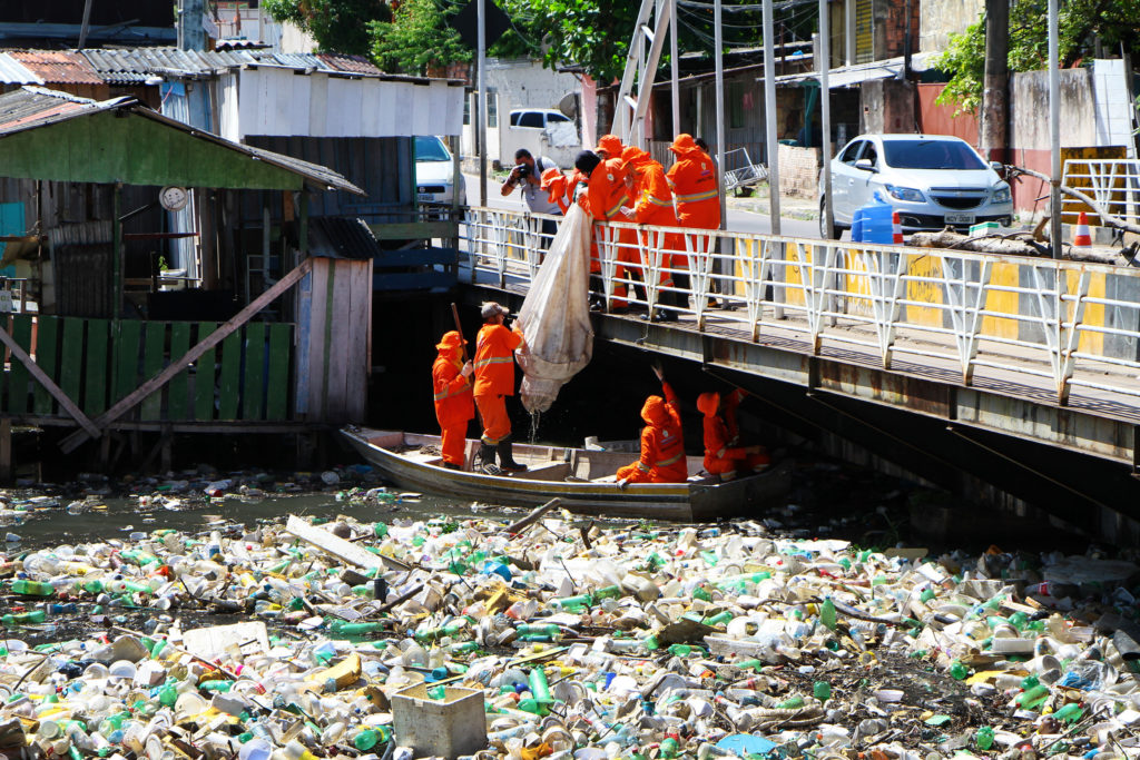 Garis recolhem lixo de igarapé com auxílio de equipes na ponte