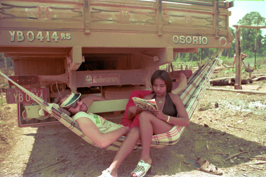 Foto de Paulo César Pereio e Edna de Cássia deitados em uma rede na traseira de um caminhão nas filmagens de Iracema.
