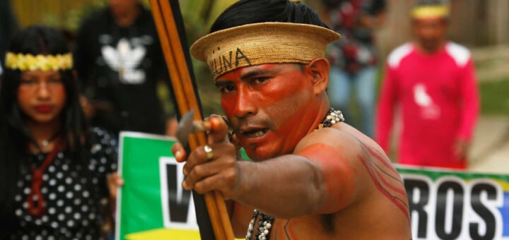 Indígena segura um arco e flecha