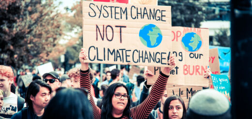 Manifestantes contra a crise climática marcham em Vancouver, no Canadá, com uma placa que diz "Mudança no sistema, não mudança climática".