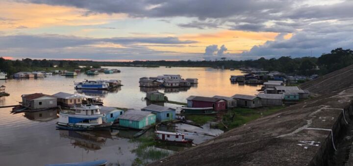 Rio Juruá, em Cauari, no estado do Amazonas, ao pôr-do-sol, com barcos no píer.