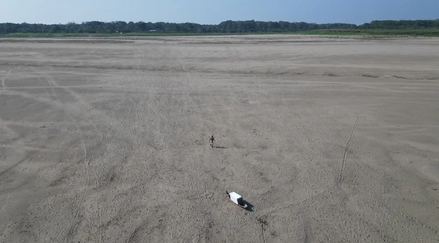 Homem caminha por onde era o leito do Rio Solimões. Foto: Antônio Caldas / Amazônia Latitude