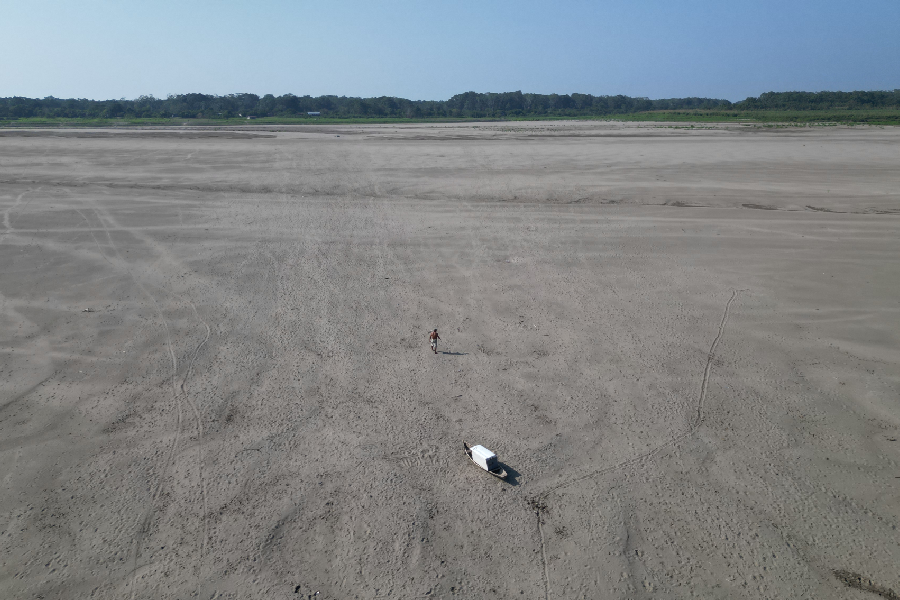 Homem caminha por onde era o leito do Rio Solimões. Foto: Antônio Caldas / Amazônia Latitude