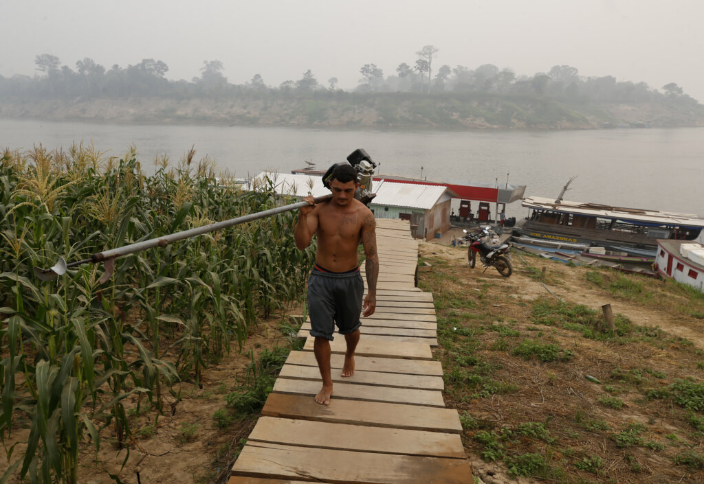O pescador, Lairton Castro da Silva (22), caminha com seu motor rabeta, sob forte fumaça de queimadas que econbre o rio Purus, na cidade de Lábrea (AM), 06 de setembro de 2024. Dados do INPE indicam que nos seis primeiros dias de setembro, já foram registrados 14.139 focos de queimadas no bioma Amazônico.