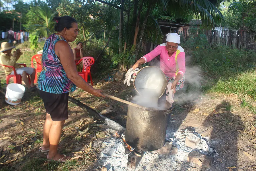 Partilha no quintal: as irmãs dedicam horas à feitura da mandicuera, um ato de união e communitas que preserva a memória familiar. Foto: Miguel Picanço.