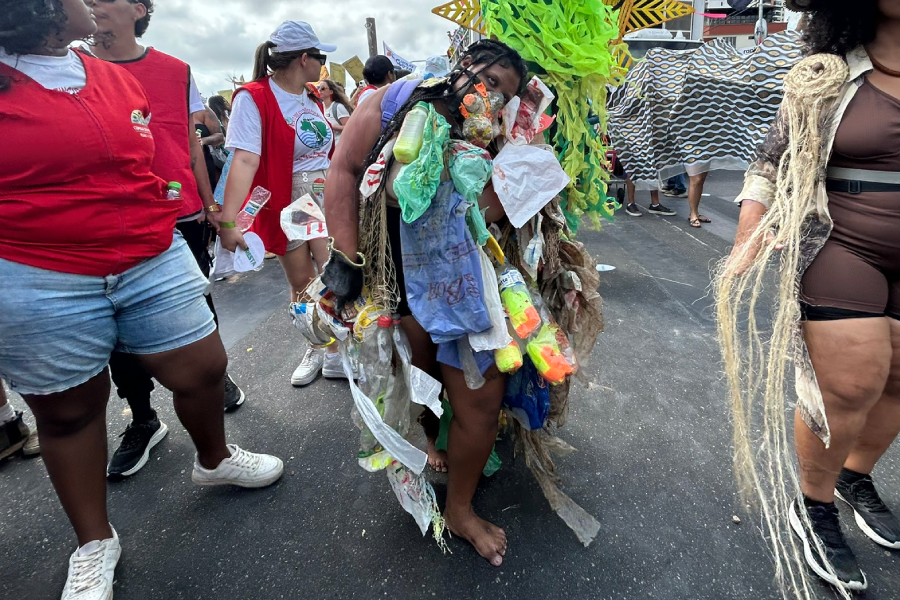 Em performance, manifestante carrega uma fantasia feita de lixo plástico, simbolizando o impacto da poluição e da cultura do descarte na vida dos rios e da Amazônia, um tema vital para a saúde do planeta. Foto: Alice Palmeira.