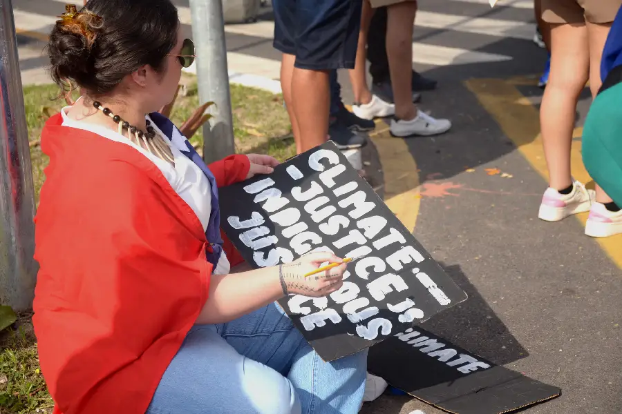 O foco na Justiça Indígena e Justiça Climática resume a essência da Marcha Mundial. Manifestante prepara sua faixa, sublinhando a conexão entre a luta dos povos tradicionais e o debate global. Foto: Isabela Leite/Amazônia Latitude.
