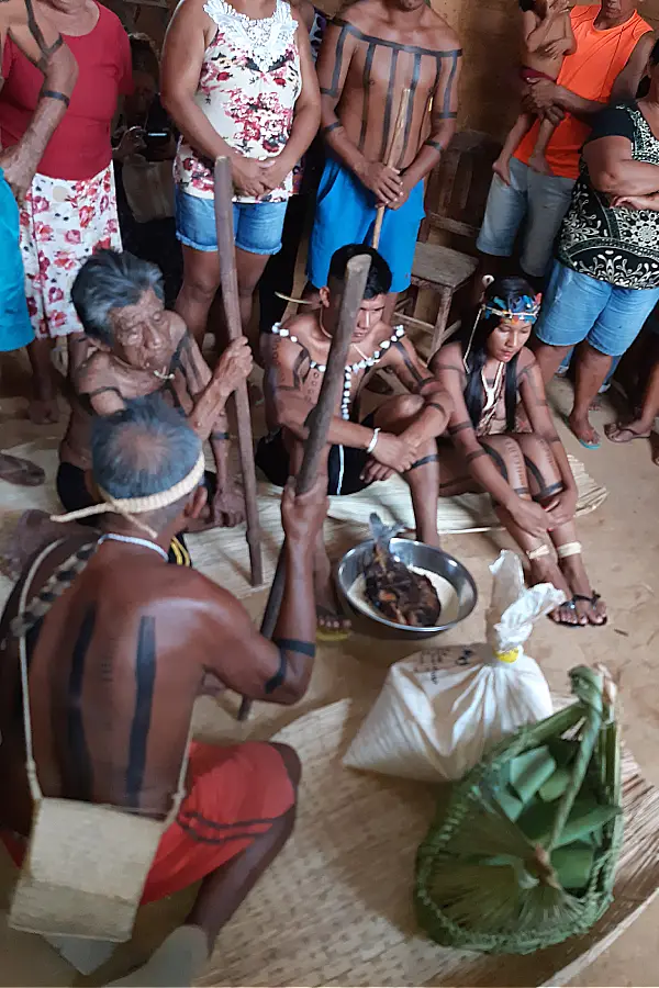 Momento central do ritual de casamento: os noivos e as autoridades (anciãos e tio da noiva) reunidos. As comidas, trazidas em cofos e ofertadas, simbolizam o sustento e a união entre as famílias Xerente. Foto: Luana Oliveira.