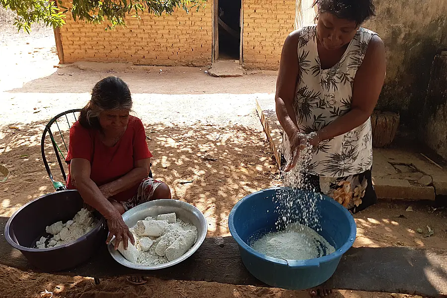 Pizadi e Suzana (in memorian) em um dos primeiros passos do Kupakubu, esfarelando a mandioca que se transformará no "bolo" sagrado para festas e rituais. Foto: Luana Oliveira.