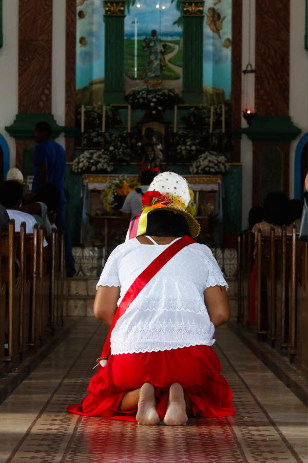 Mulher ajoelhada dentro da igreja em gesto de devoção durante a Festividade de São Benedito, em Bragança. Foto: Oswaldo Forte/Amazônia Latitude.