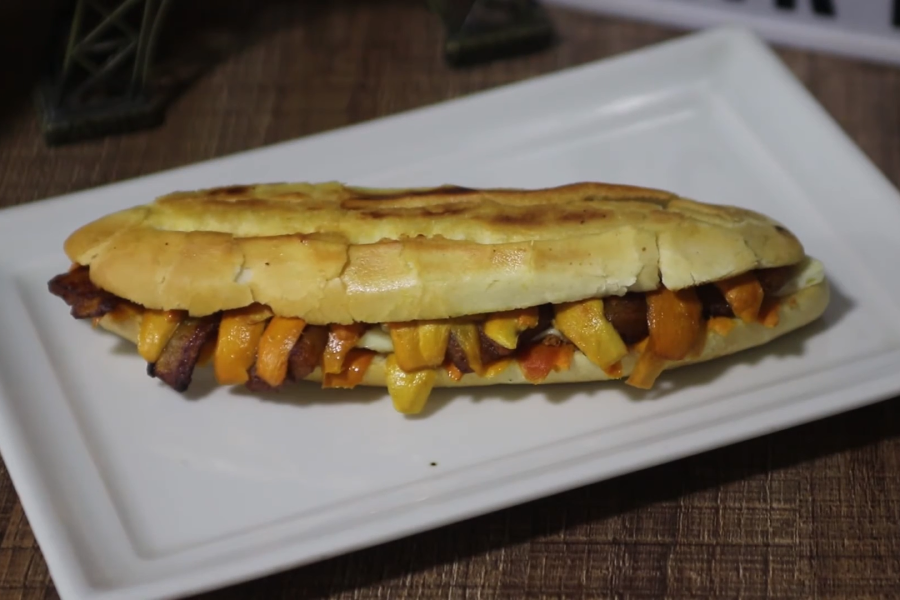 O X-Caboquinho, ao ser entregue na mão do trabalhador às margens da aurora, é lembrança moldada em pão, é geografia que se dobra para caber entre os dedos. Foto: Turismo Aqui via Youtube.