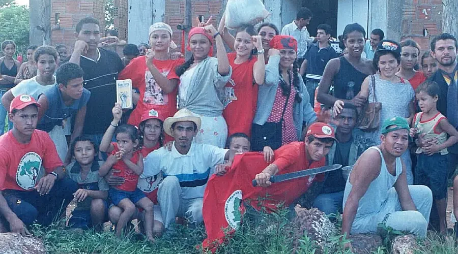 A mística da permanência: jovens do Assentamento Califórnia em 2002, logo após uma encenação da ocupação da fazenda, em frente à igrejinha de São José. Vinte e quatro anos depois, a maioria dessas pessoas formou suas próprias famílias no território. Foto: Acervo Assentamento Califórnia.