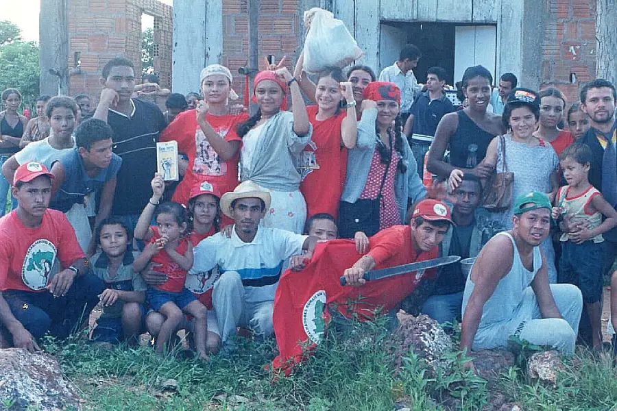 A mística da permanência: jovens do Assentamento Califórnia em 2002, logo após uma encenação da ocupação da fazenda, em frente à igrejinha de São José. Vinte e quatro anos depois, a maioria dessas pessoas formou suas próprias famílias no território. Foto: Acervo Assentamento Califórnia.