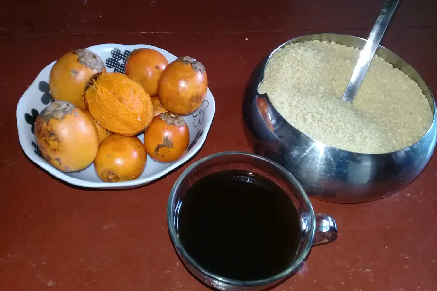 A tríade do cotidiano: o tucumã recém-lascado, a crocância da farinha d’água e o café quente. Um rito de comensalidade que organiza as manhãs e sustenta o corpo para o trabalho no roçado ou na cidade. Foto: Miguel Picanço/Amazônia Latitude.
