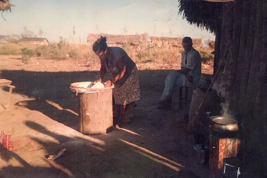 Dona Antônia da Silva Costa e Seu Justino Gomes Costa (in memoriam) em registro de 1996 na Vila Velha. A imagem captura o cotidiano de trabalho e a precariedade das primeiras moradias de palha. Foto: Acervo Assentamento Califórnia.