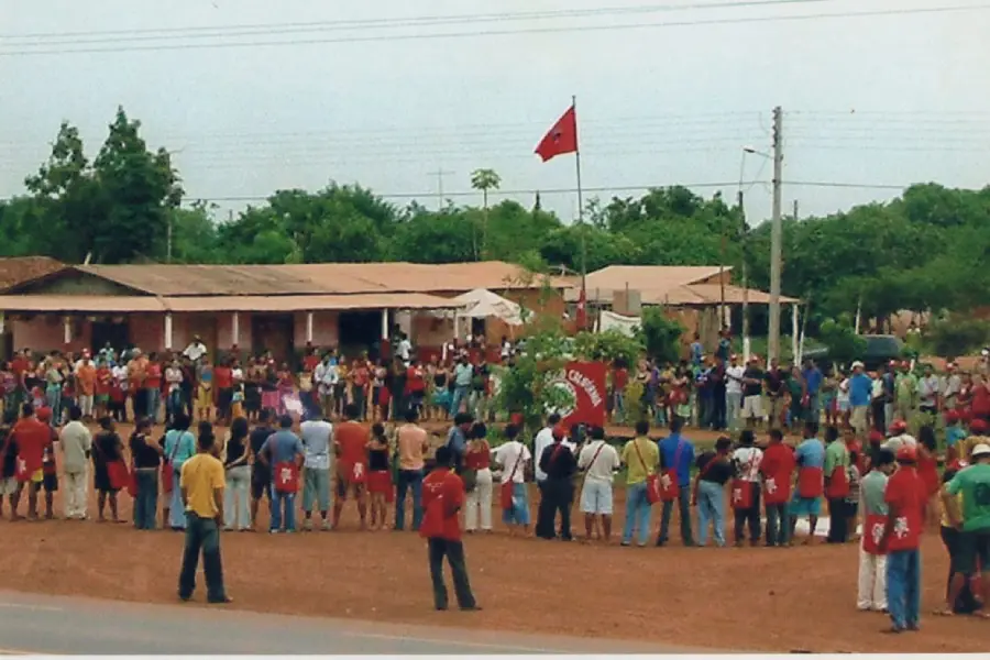 Momento da troca de bandeiras após caminhada pelas ruas do assentamento. A atividade reafirma o compromisso coletivo com a reforma agrária. Foto: Acervo Assentamento Califórnia.