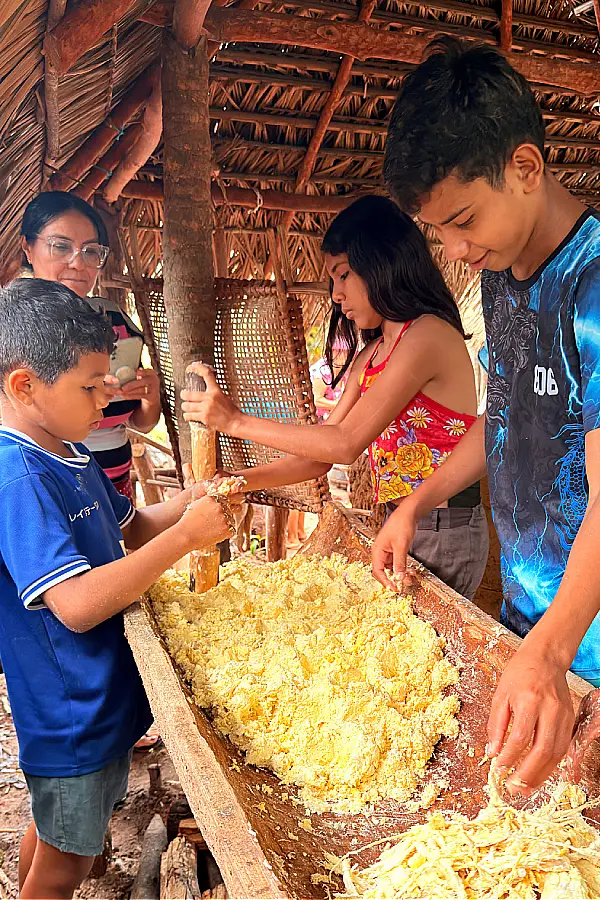 Continuidade: jovens aprendem a cevar a mandioca, garantindo a transmissão do saber entre gerações. Foto: Miguel Picanço/Amazônia Latitude.