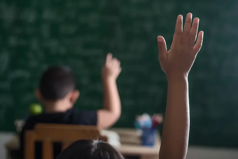 O gesto de levantar a mão marca o momento da escolha coletiva em sala de aula, onde aprender também passa por decidir. Arte: Loan Bastos/Amazônia Latitude.