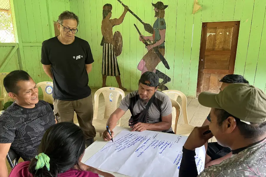 Sergio Nantip e Edwin Zárate observam enquanto o paraecólogo Claudio Ankuash Nantip escreve ideias para o programa da Ecoforensic. Foto: Katie Surma/Amazônia Latitude.
