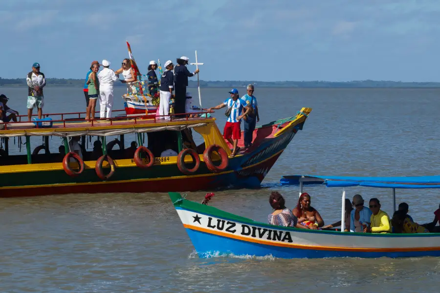 Grandes embarcações regionais e barcos menores, como o "Luz Divina", cruzam-se durante o percurso em direção à comunidade de Mocooca, consolidando um dos registros visuais mais potentes da identidade pesqueira da região. Foto: Oswaldo Forte/Amazônia Latitude.
