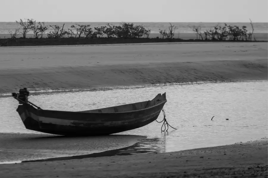 Raveta repousa ancorado em um canal de maré baixa na Ilha de Maiandeua. A embarcação, que aguarda o retorno das águas, sintetiza a íntima e silenciosa relação entre o tempo, o homem e a natureza no litoral paraense. Foto: Oswaldo Forte/Amazônia Latitude.