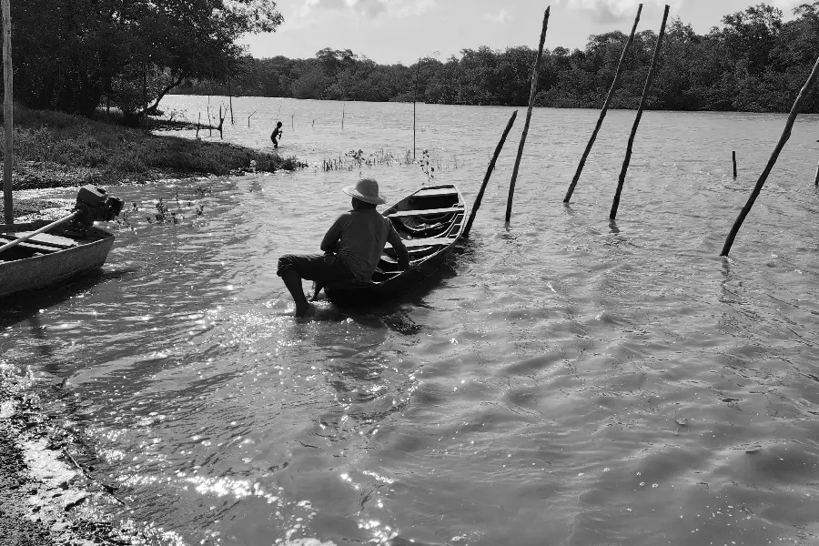 Responder ao chamado do mundo em fluxo. O pescador observa o porto e o nível da água antes de partir, integrando seu tempo biológico ao tempo da lua e ao movimento das marés. Foto: Miguel Picanço/Amazônia Latitude.