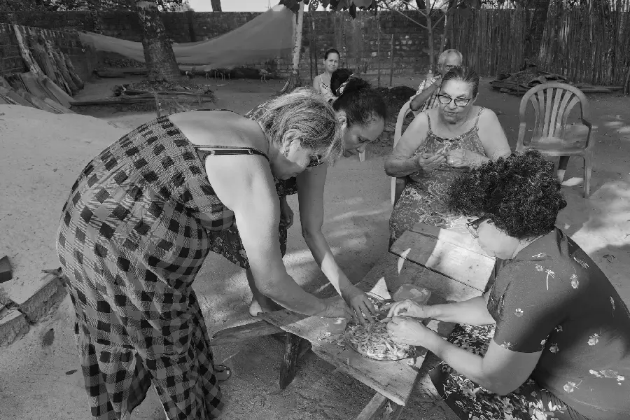 Sentados ao redor da mesa de madeira, o descascar coletivo do camarão expressa uma aprendizagem sensível e uma comensalidade que recusa a lógica puramente mercantil. Foto: Miguel Picanço/Amazônia Latitude.