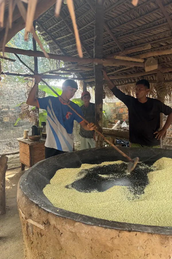 Jovens e mandiocultores torrando a farinha no grande tacho do forno de barro: trabalho coletivo, aprendizado prático e continuidade dos saberes. Foto: Miguel Picanço/Amazônia Latitude.
