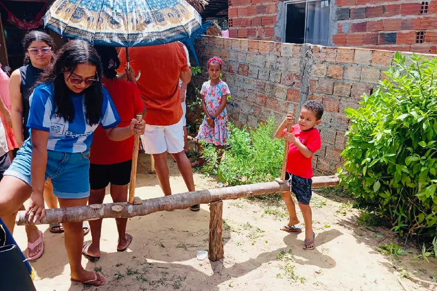 Crianças e adultos vivenciando brinquedos e dinâmicas tradicionais de madeira no quintal: a pedagogia sensível e o encontro intergeracional. Foto: Miguel Picanço/Amazônia Latitude.