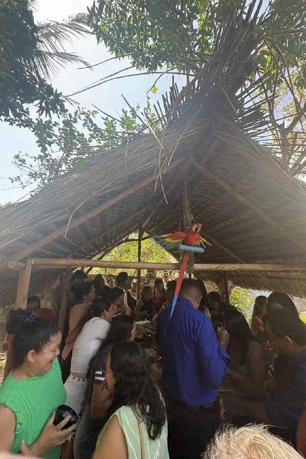 A vivência da comensalidade e do encontro: comunitários e visitantes lotam a mesa posta sob a cobertura de palha do Quintal Ancestral. Foto: Miguel Picanço/Amazônia Latitude.
