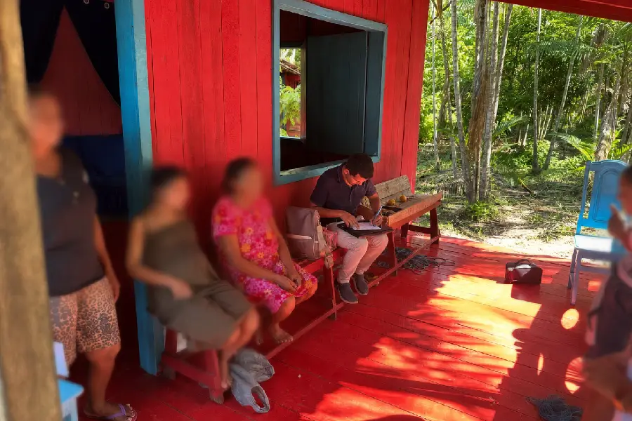 O médico Fagner Carvalho durante atendimento em comunidade ribeirinha: a rotina clínica adaptada à realidade das casas de madeira no interior da Amazônia. Foto: Fagner Carvalho/Acervo Pessoal.
