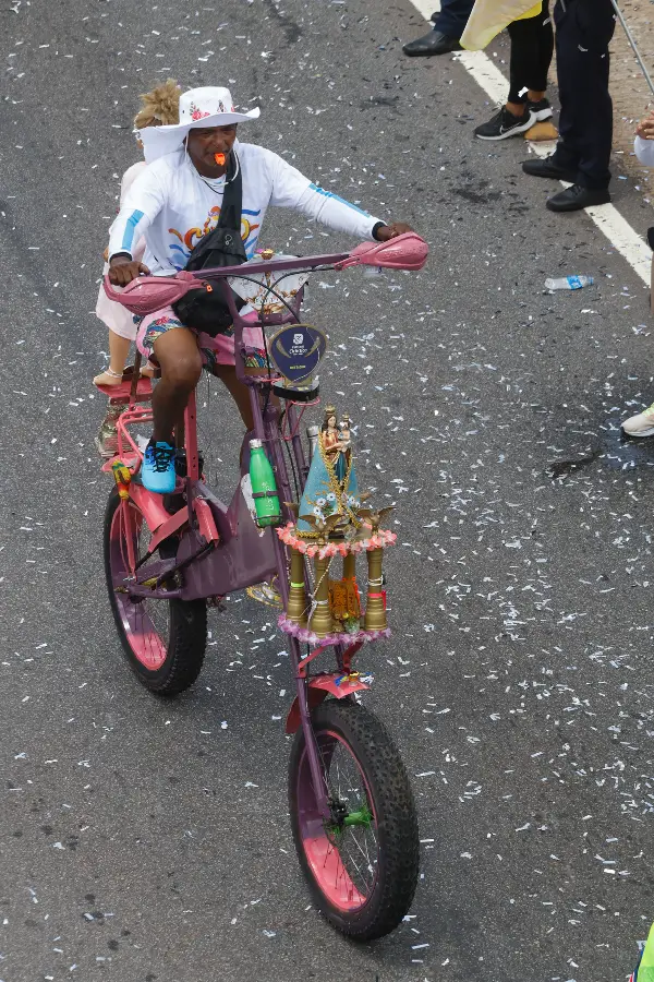 A fé em movimento: um devoto pedala sua bicicleta customizada, transformada em um andor móvel com uma imagem de Nossa Senhora de Nazaré e adornos dourados. Uma mistura da criatividade popular à tradição da procissão. Foto: Oswaldo Forte/Amazônia Latitude.