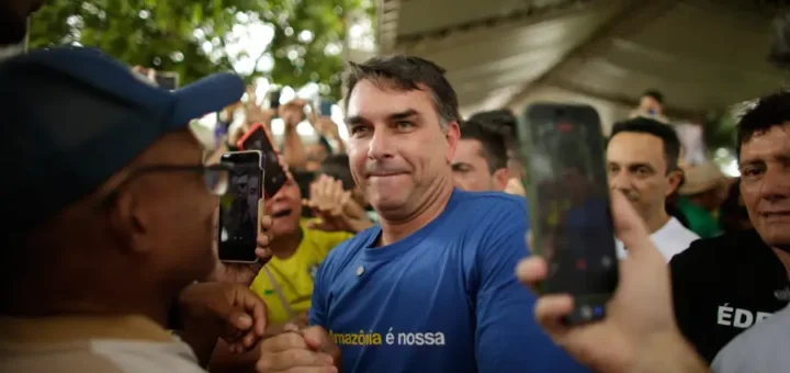 O Heredofascimo da família Bolsonaro ameaça o sistema respiratório do planeta. Flávio Bolsonaro veste camisa "A Amazônia é nossa" enquanto negocia minerais críticos e poder sobre a política de segurança interna nacional com os EUA. Raimundo Paccó/Sumaúma.