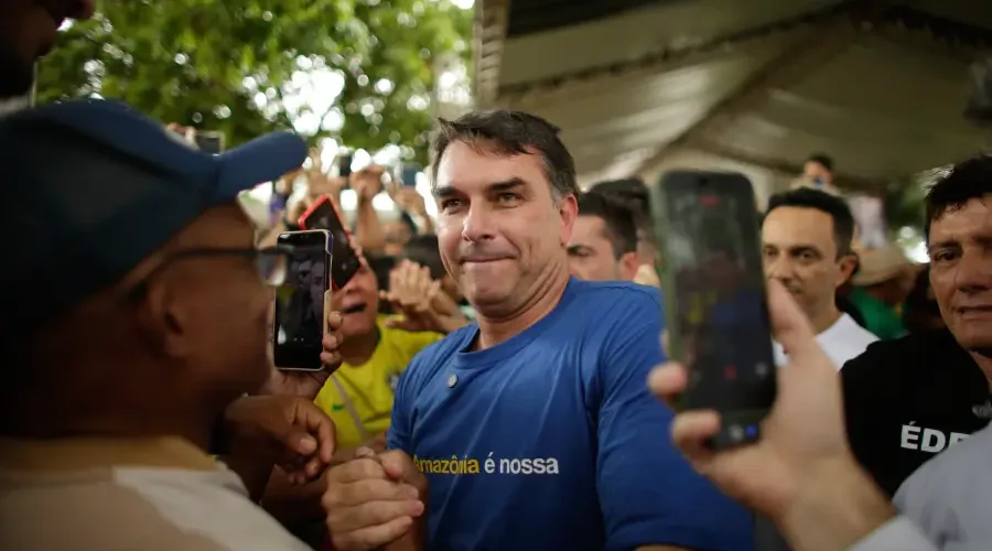 O Heredofascimo da família Bolsonaro ameaça o sistema respiratório do planeta. Flávio Bolsonaro veste camisa "A Amazônia é nossa" enquanto negocia minerais críticos e poder sobre a política de segurança interna nacional com os EUA. Raimundo Paccó/Sumaúma.