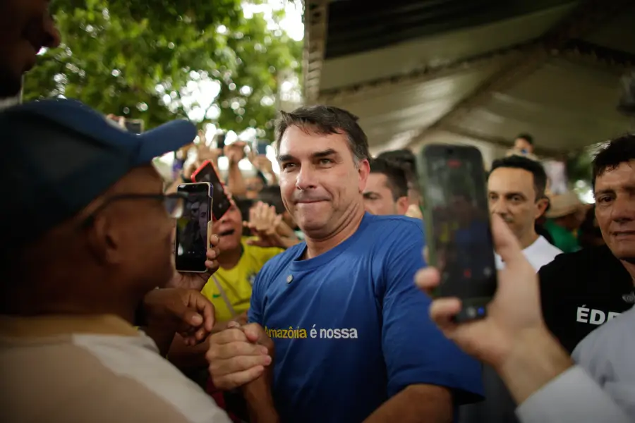 O Heredofascimo da família Bolsonaro ameaça o sistema respiratório do planeta. Flávio Bolsonaro veste camisa "A Amazônia é nossa" enquanto negocia minerais críticos e poder sobre a política de segurança interna nacional com os EUA. Raimundo Paccó/Sumaúma.