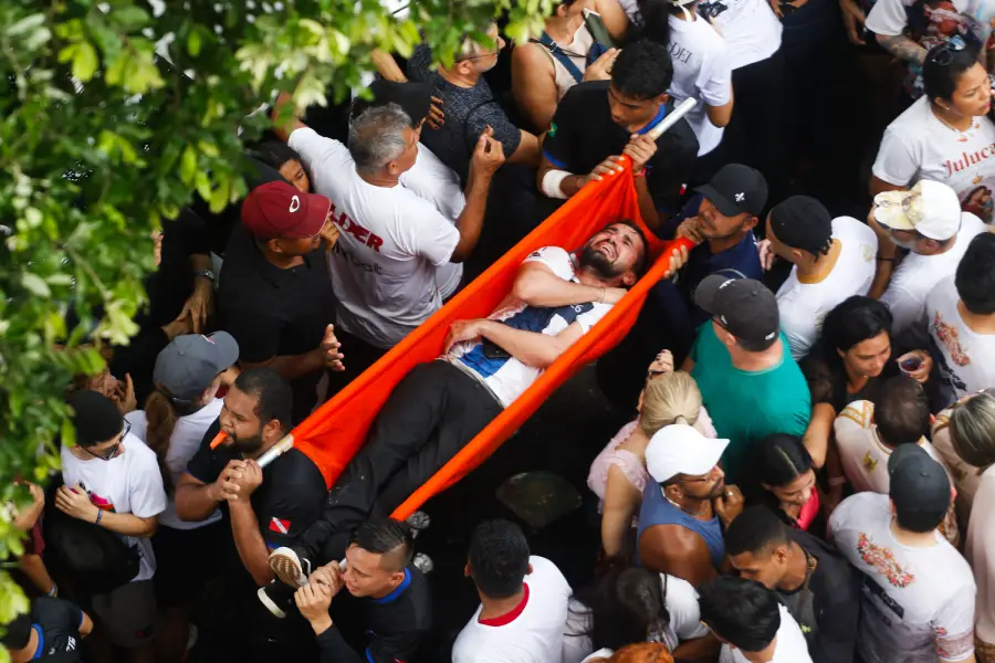 O auge da devoção e o limite do corpo: romeiro é carregado pelos próprios fiéis, com o rosto tomado pela dor e pela emoção, em um mar de gente que testemunha o sacrifício da promessa. Foto: Oswaldo Forte/Amazônia Latitude.